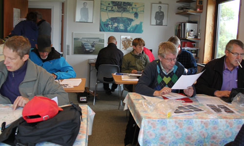 Der er godt pakket med deltagere i Tønder Flyveklubs klubhus, og koncentrationen lyser ud af deltagerne under planlægningen af navigationsturen
